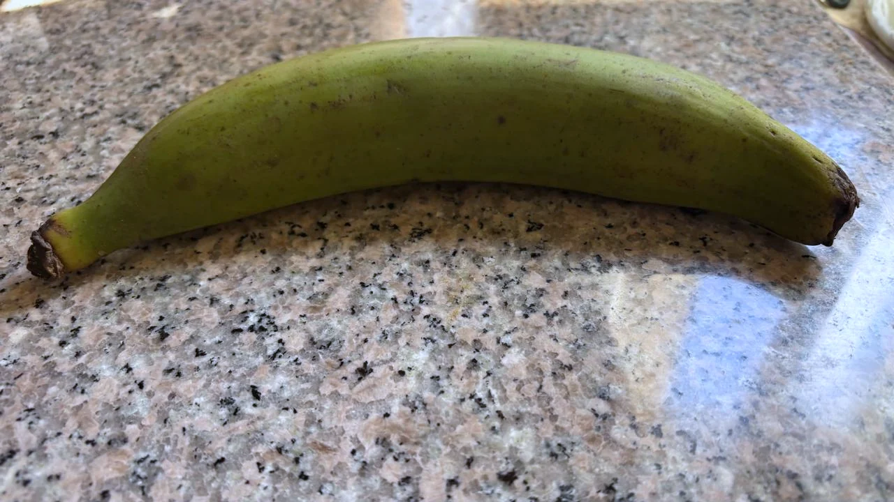Kokonainen keittobanaani, jonka kuori on reseptin vaatimaa vihreää ja kovaa.
