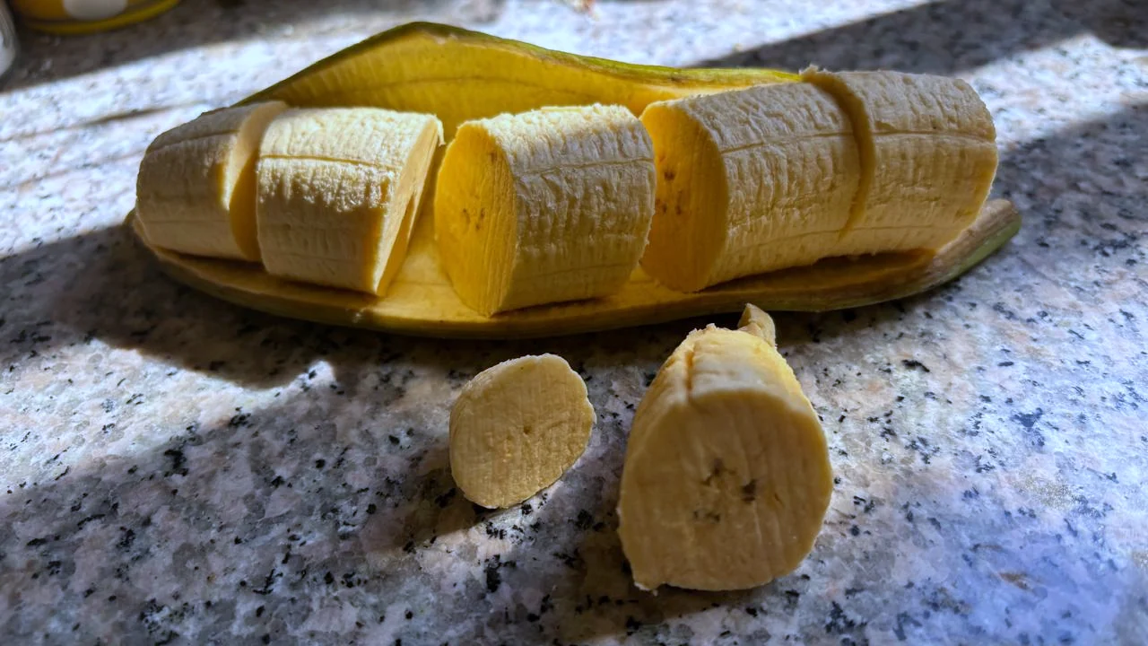 Kuorittu ja paksuiksi paloiksi leikattu keittobanaani oman kuorensa päällä.