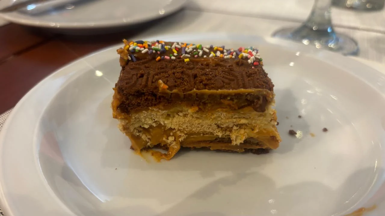 Fatia de chocotorta em um prato branco mostrando as camadas internas de recheio e biscoito