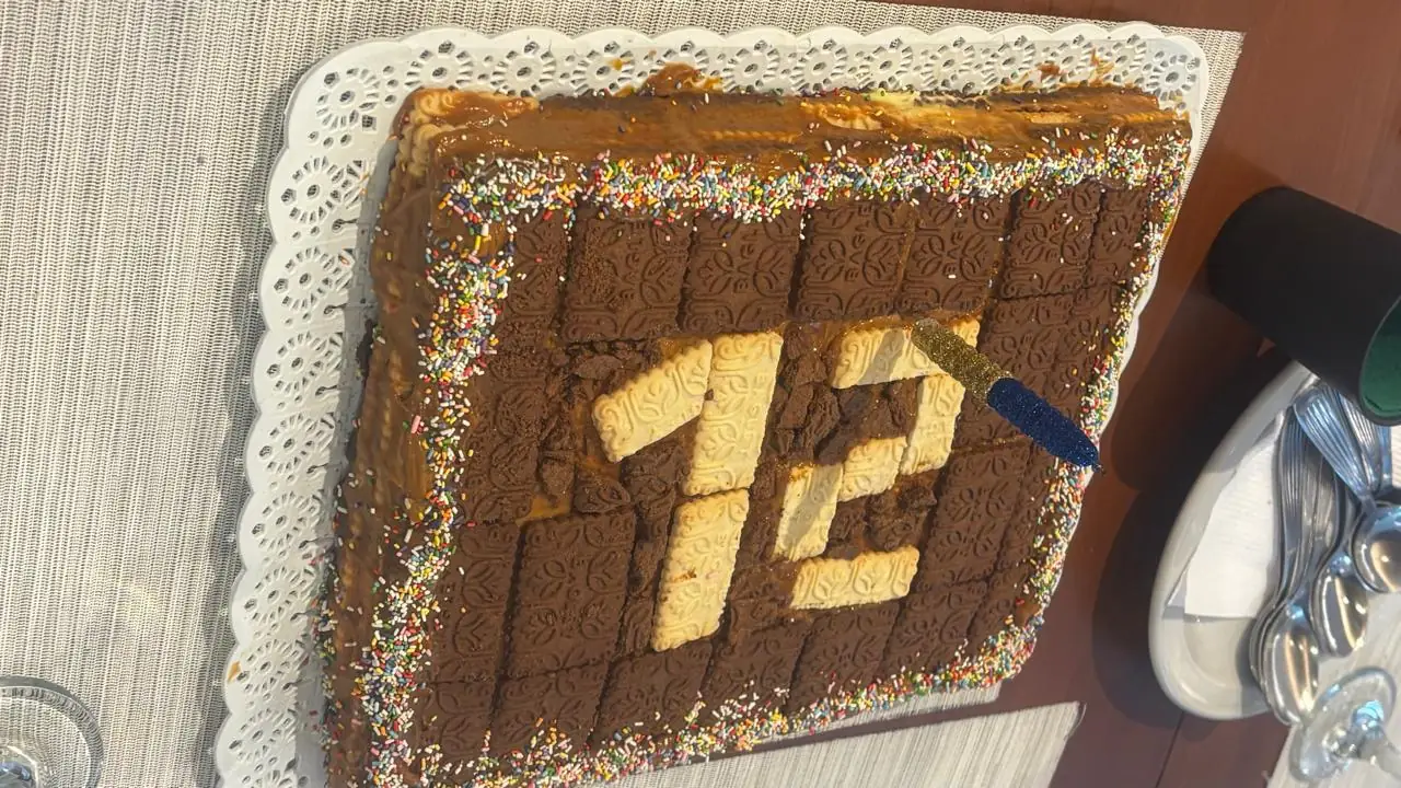 Chocotorta retangular decorada com confeitos coloridos e o número doze feito de biscoitos claros
